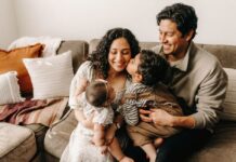 Una familia que funciona: cuidar hoy lo que queremos conservar mañana Padres con sus dos hijos pequeños compartiendo un momento de afecto y cercanía en casa.